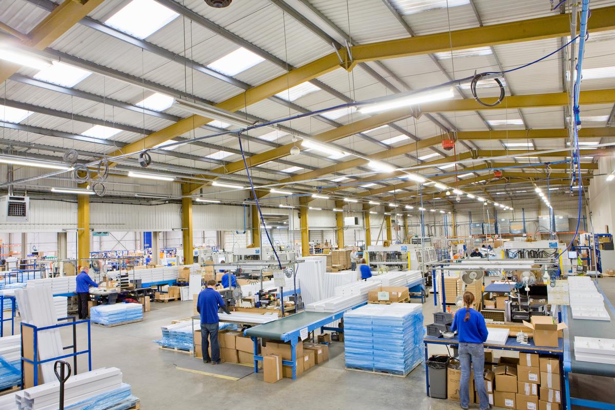 A wide shot of workers on a production line in an aluminum light fittings factory.
